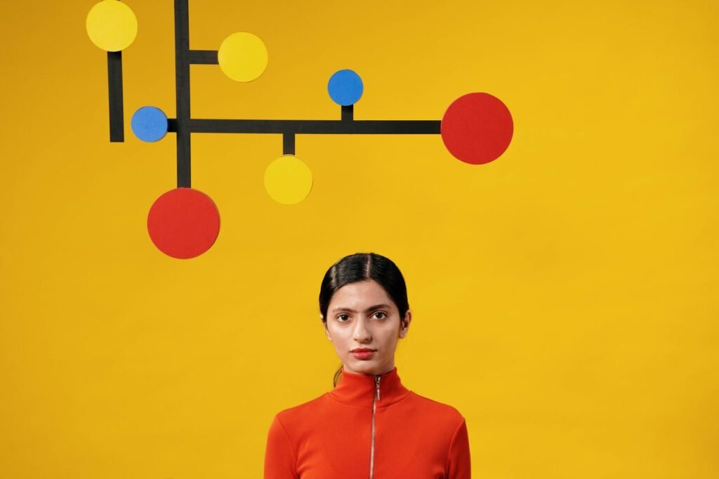 Portrait of a woman in red with a colorful geometric background featuring yellow and blue circles.